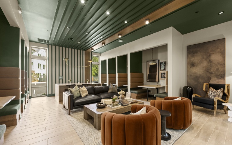 Resident lounge with couch and large chairs, and private co-working booths